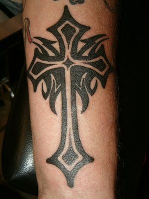 A tattoo of a cross mixed with a tribal look to it i am doing this tattoo with my own style 