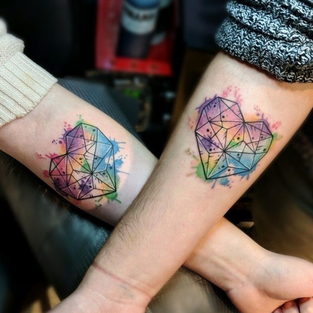 Watercolor hearts tattoo located on the inner arm