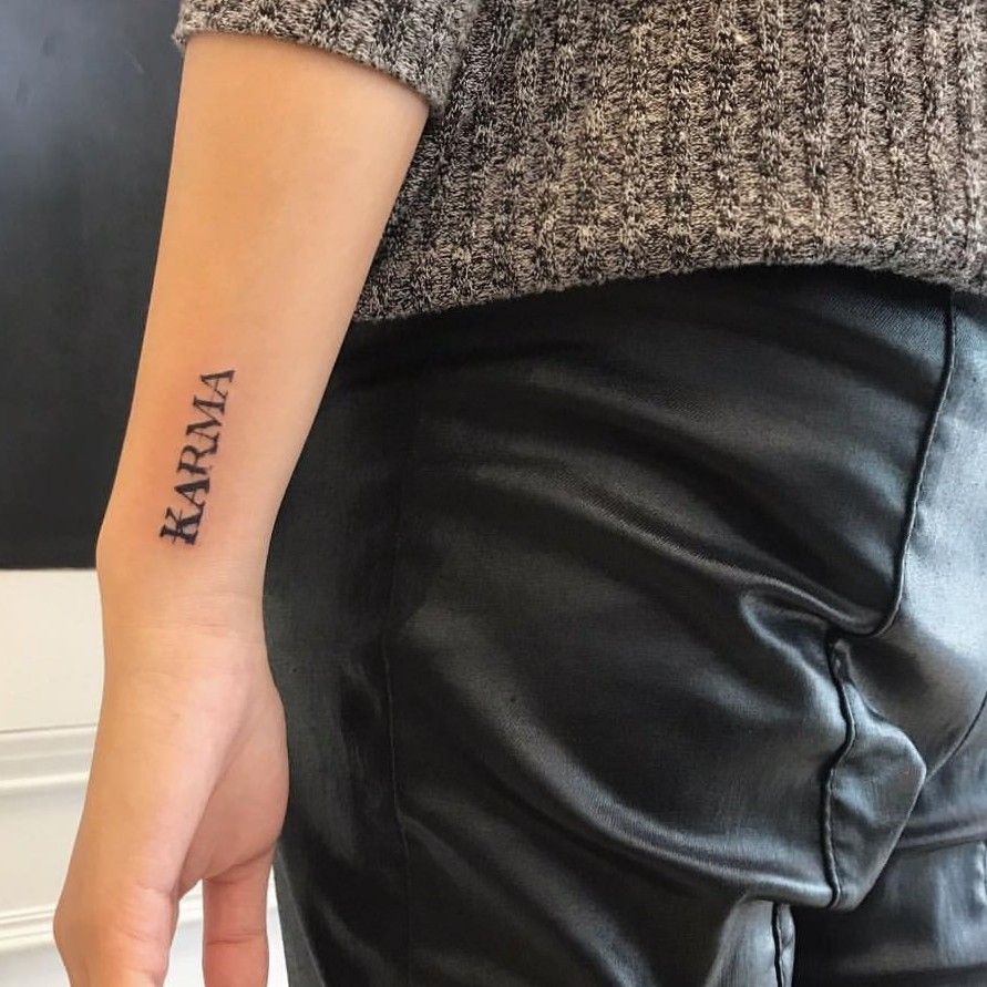 Hand poked word karma tattooed on the bicep done in