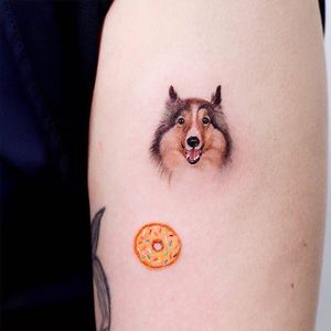 Tattoo by Haeny Tattoo #HaenyTattoo #dogtattoos #dogtattoo #pup #petportrait #puppy #animal #nature #mansbestfriend #color #realism #realistic #hyperrealism #watercolor #small #tiny #donut
