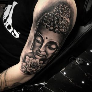 Black and white realism buddha tattoo on shoulder and bicep.