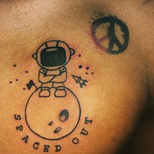 Space tattoo on chest and peace