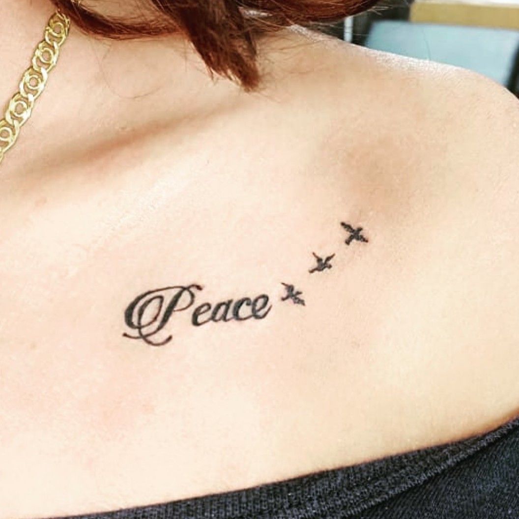 Healed tattoo of the word peace done on the tricep