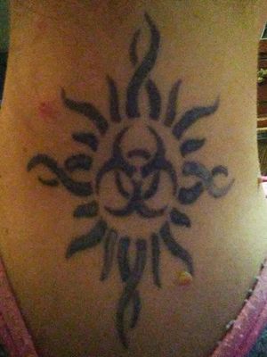 Godsmack Logo with Biohazard symbol in the center. A friend from high school drew this and got it on the back of his neck but smaller, he said he'd pay for mine so I said yea but got it bigger. It needs re-doing cuz the guy dug into me a lot and I started bleeding the ink out. He was shorter than me and had me sit on the table Indian style and did the whole tattoo on his tip toes which had me thinking WTF but its all good 😏