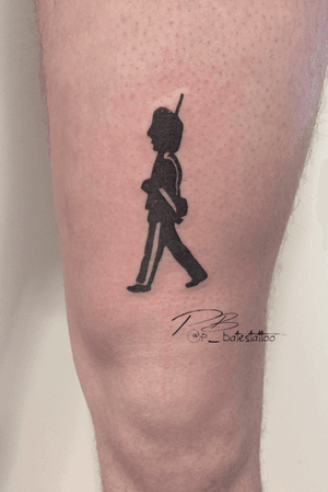 Capture the bravado of a soldier with this blackwork gun, soldier, and hat illustration by Patrick Bates on your upper leg.