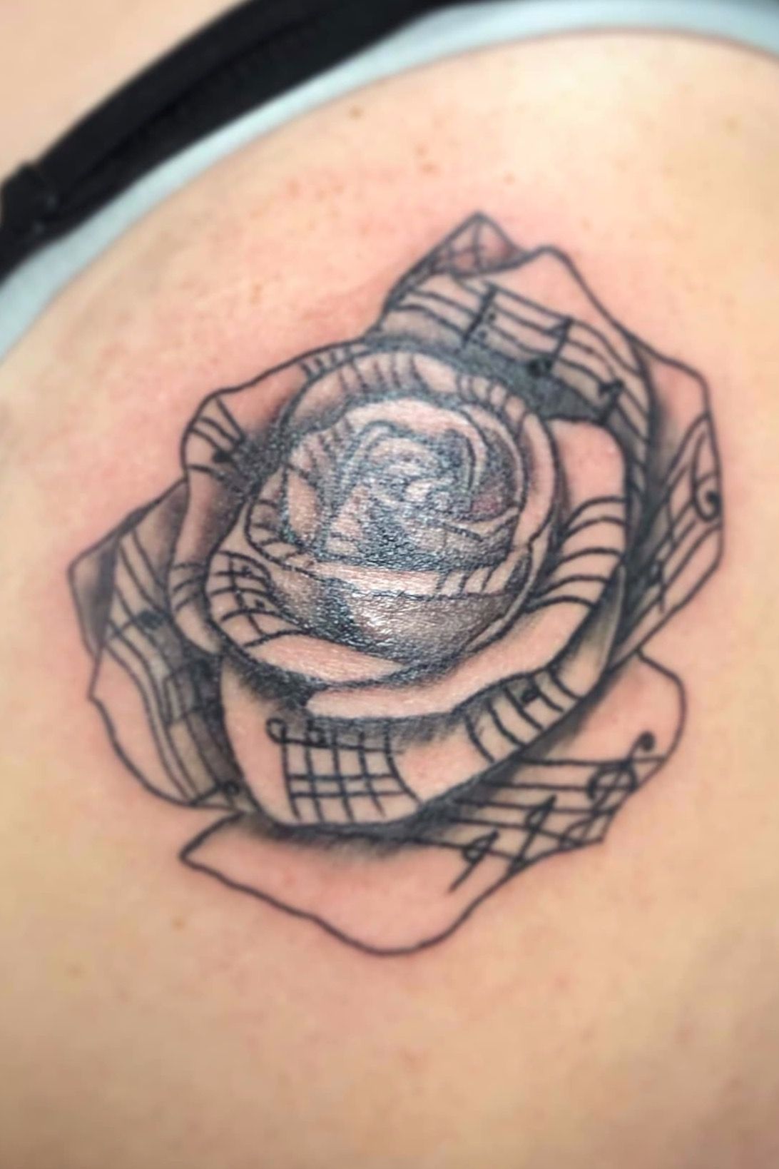 Peony and treble clef tattoo done in fine line located
