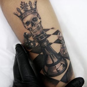 One line chess queen tattoo located on the inner arm.