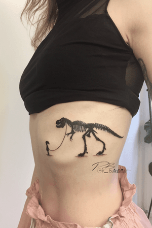 Illustrative blackwork tattoo of a dino and girl by Patrick Bates, beautifully crafted on the ribs.