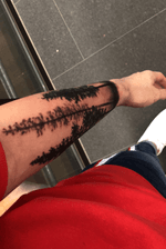 Minimalistic forest tattoo on lower left arm