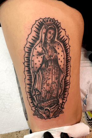 Black and grey traditional virgin mary tattoo on a thigh 
