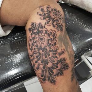 Beautiful chrysanthemum tattoo by Dani Mawby on the lower leg, showcasing detailed illustrative style.