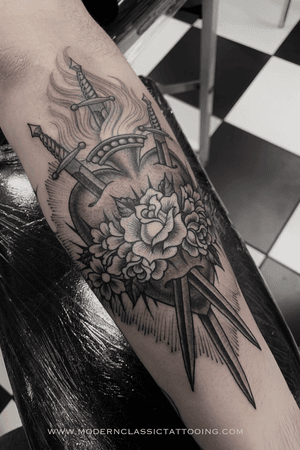 Get a stunning tattoo of a rose, heart, and sword in fine line traditional style on your forearm in London, GB.