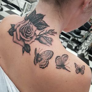 Discover the elegant beauty of this blackwork tattoo featuring a stunning butterfly and flower design by Dani Mawby.