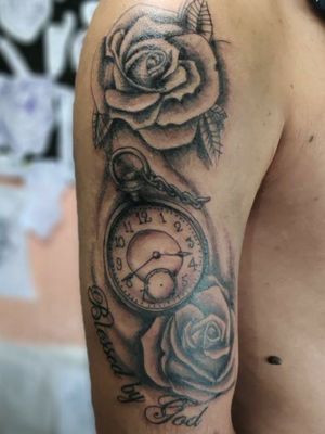 Tatuagem relógio com rosas, e a frase "Blessed by God" no braço masculino Andrade Ink Tattoo Whats: 4298575342