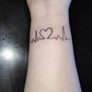Tatuagem feminina delicada no pulso, com batimentos cardíacos formando coração Andrade Ink TattooWhats: 4298575342