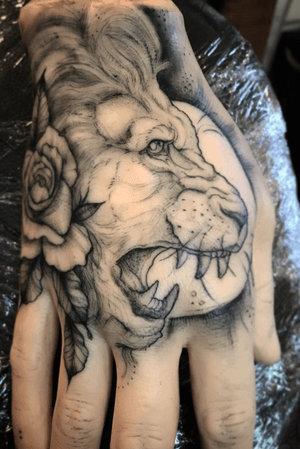 Illustrative black and grey lion head, this design is on a rubber hand and available to be tattooed on a person.