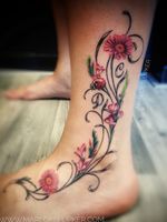 Elegant ankle tattoo with pink flowers and a cute ladybug #ankletattoo #curlytattoo #pinkflower #ladybug #elegant #feminine #initials #gladiolus 
