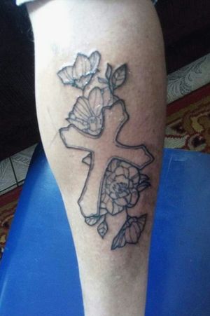 Tattoo de cruz com flores feitas em um cliente