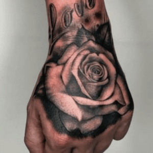 Rose on hand by Realism artist and owner Aaron Clarke.