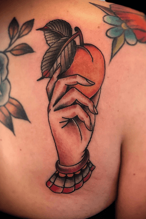 Female Hand holding a Peach Tattoo on the Shoulder