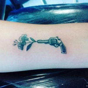 Gun with flowers tattoo