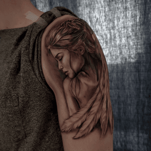 Jones' blackwork tattoo featuring a woman with a delicate feather design on the upper arm.
