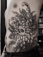 Skull and chrysanthemum on ribs.