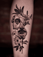 Broken Marcus Aurelius with flowers on leg.