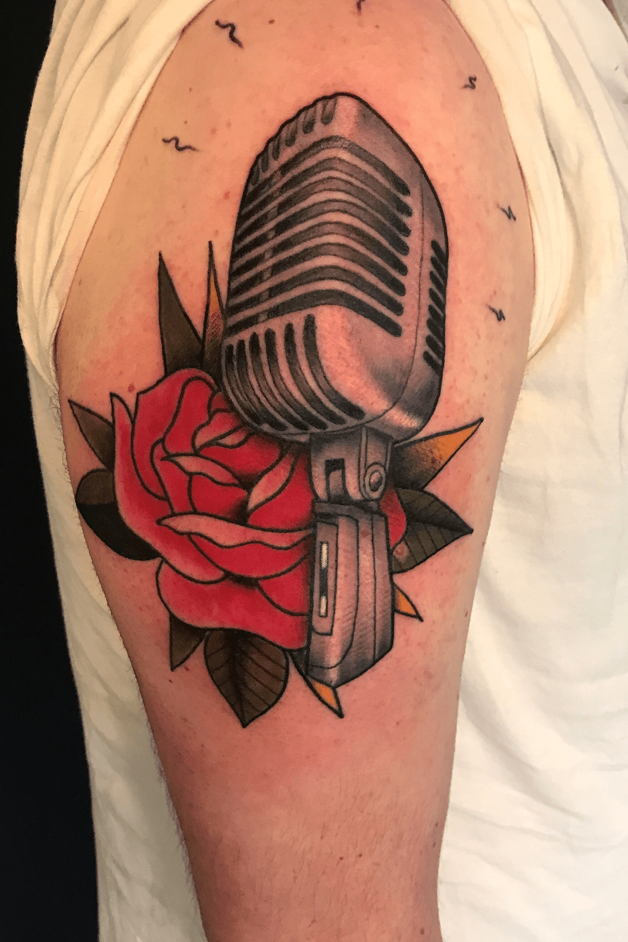 New school microphone tattoo on the inner forearm