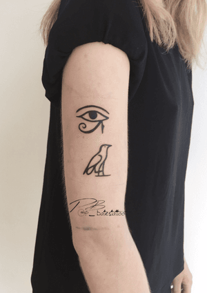 Exquisite illustrative tattoo of a bird with Horus eye on upper arm by Patrick Bates