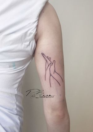 An illustrative hand tattoo on the upper arm by talented artist Patrick Bates, featuring intricate fine line work.