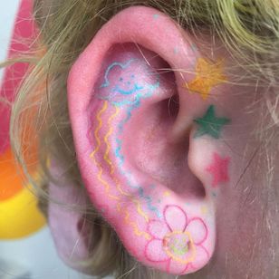 El tatuaje favorito de esta semana de Pina Tattoos #favorittattoos #best tattoos #awesometattoos #tattooidea #cooletattoos #uniquetattoos #tattooinspiration #eartattoo #rainbow #clouds #flower #stars #smileyface