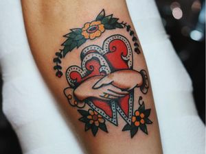 Tattoo of a hand by Liam Alvy #LiamAlvy #forearm #arm #tattoosofhands #tattoohand #handtattoo #hands #fingers #flower #floral #heart #holdinghands #traditional #color