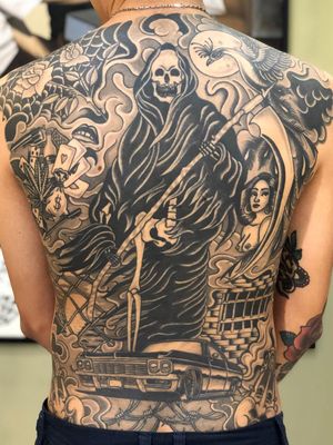Chicano tattoo by #AlejandroLopez #chicano #chicanotattoo #blackandgrey #traditional #oldschool #illustrative #reaper #car #lowrider #barbedwire #weed #cards #dice #lips #jail #scythe #skull #backpiece #back