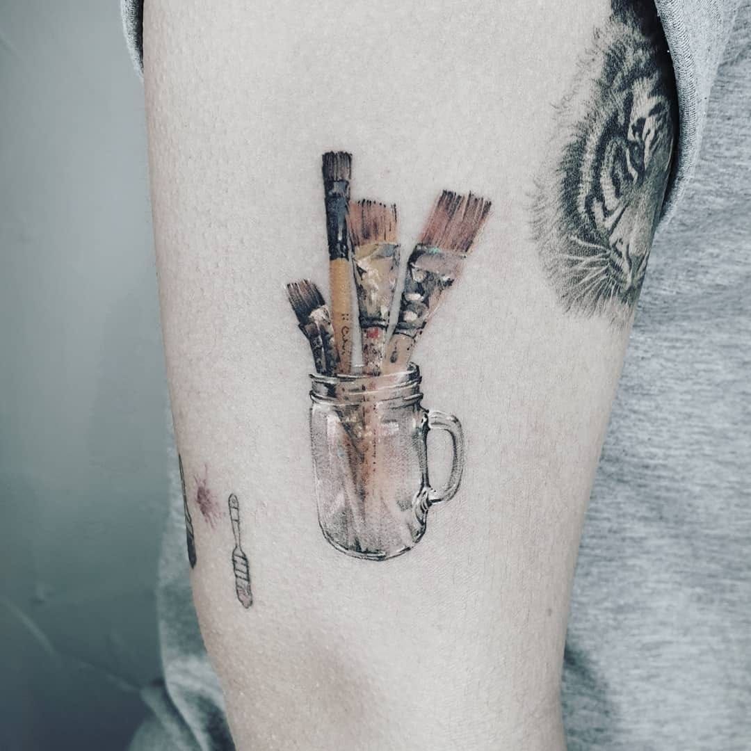 Arm with Tattoo Holding Paintbrush  Free Stock Photo