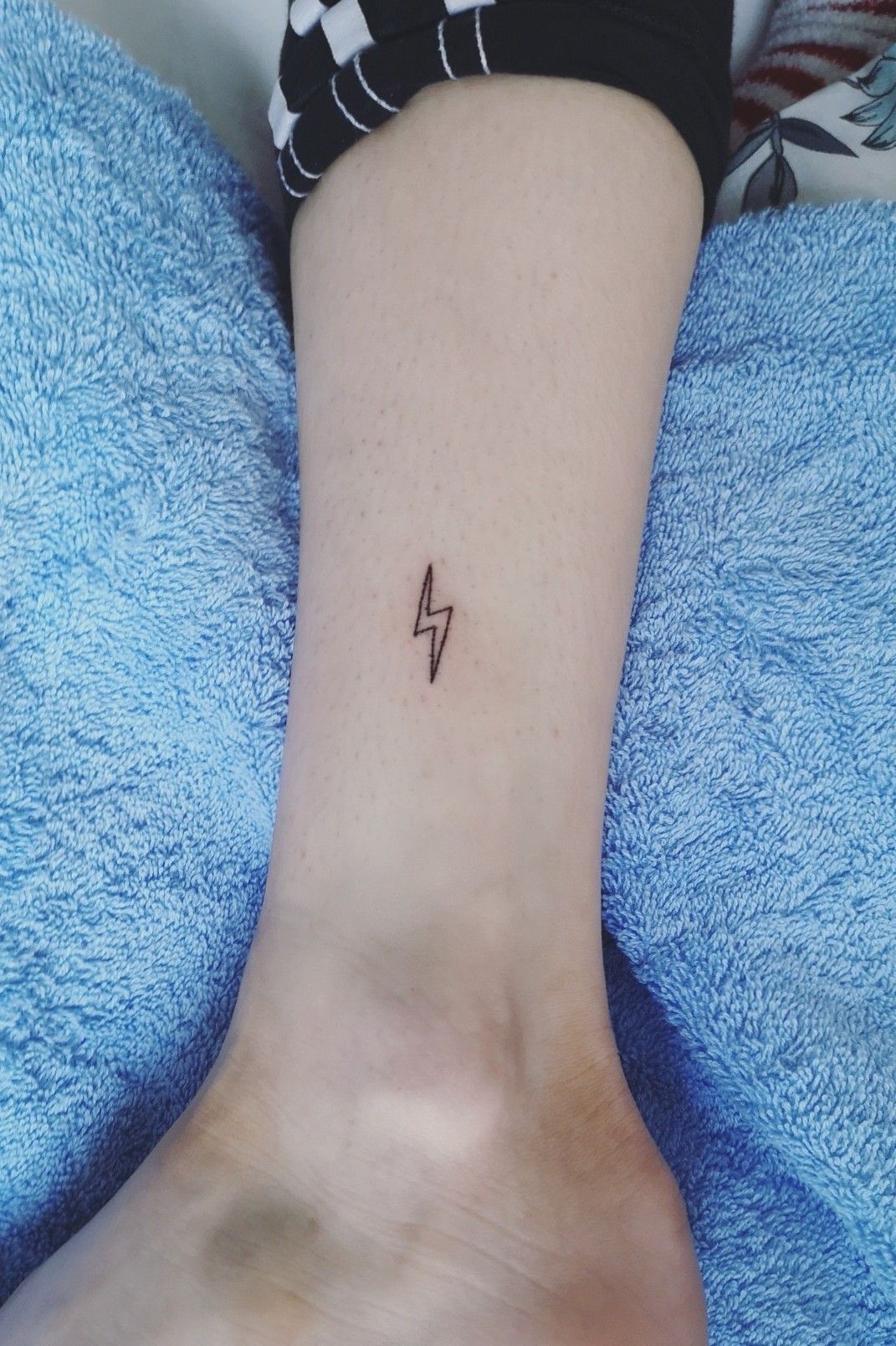 Tiny lightning bolt tattoo on the ankle