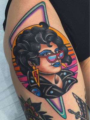 Rockabilly girl poses with her tattoos at amusement park with neon