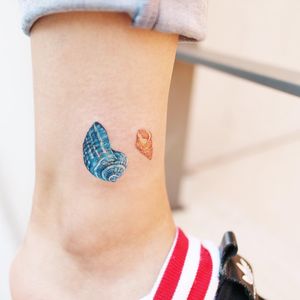 Colorful tattoo by Guseul #Guseul #lowerleg #leg #ankle #shells #conch #realistic #realism #watercolor #colorfultattoo #colorful #color #vibrant