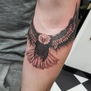 Bold blackwork design by Dani Mawby, showcasing a powerful eagle motif on the arm.