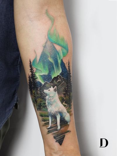 Beautiful tattoo by Deborah Genchi #DeborahGenchi #debartist #realism #realistic #illustrative #watercolor #color #wolf #animal #mountain #landscape #nature #stars #sky #trees #auroraborealis #forearm #arm
