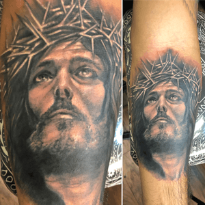 Black and gray surrealistic jesus piece on forearm
