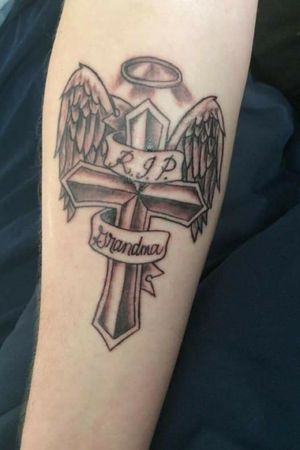 Cross and ribbon with angel wings and a halo, dedicated to my grandmother. First ever tattoo, would like to get it touched up eventually.