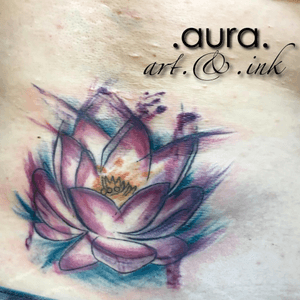 Watercolor lotus lower back tattoo.