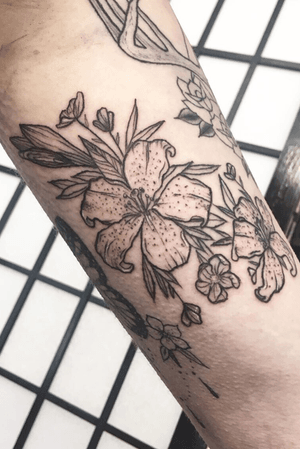 Lily and cherry blossom bunch on arm, blakwork and white highlights. Slightly red due to swelling!