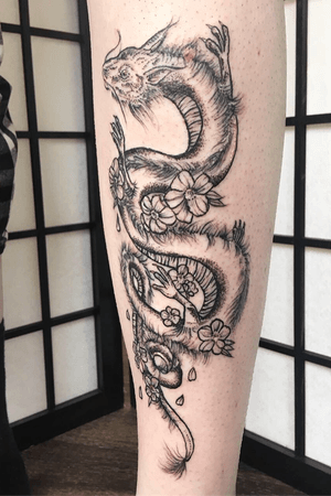Oriental dragon piece placed on the shin. Mainly dotwork and some whipshading in the flowers. Blackwork and white highlight.