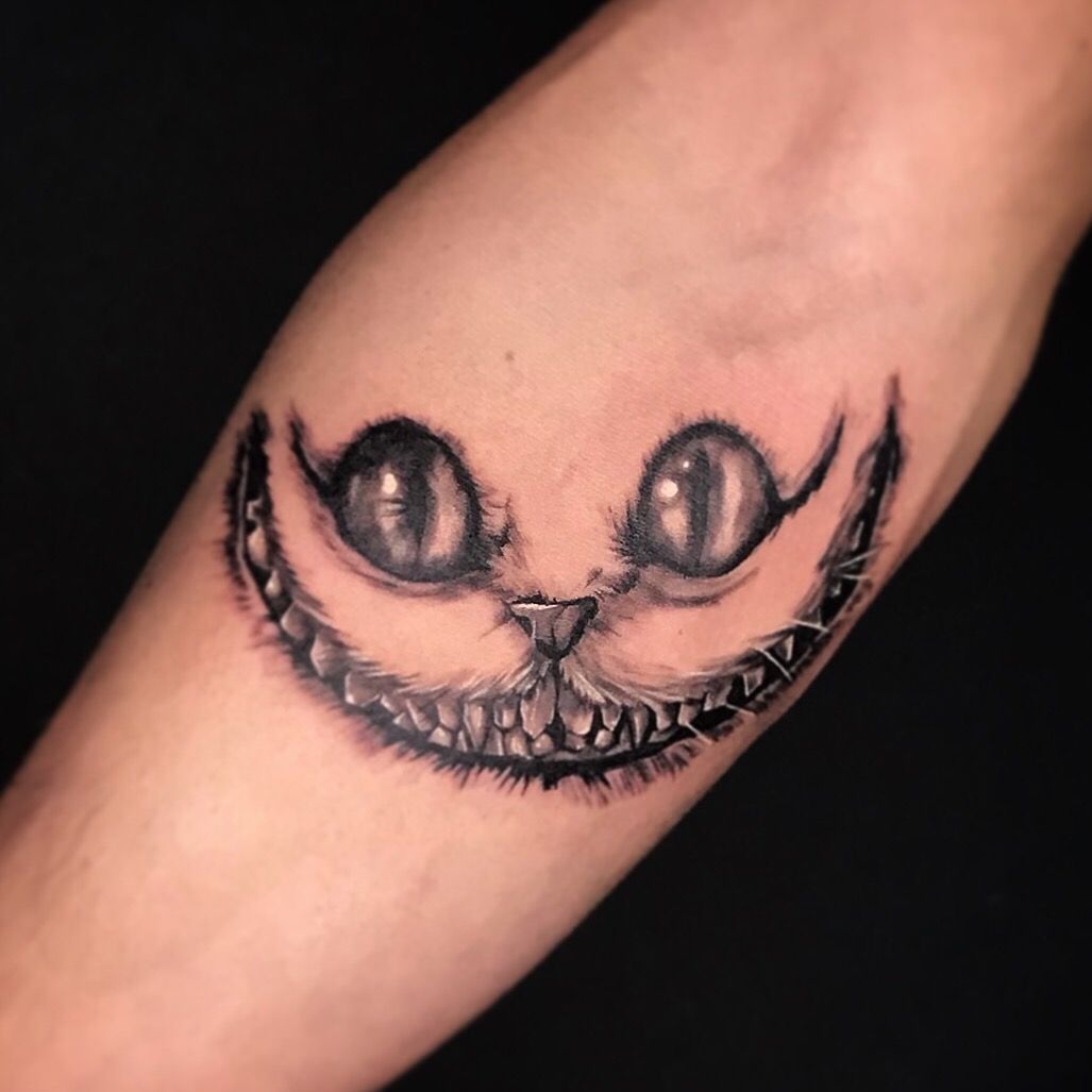 Cheshire Cat tattoo located on the inner forearm