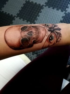 Realistic skull and a moth that carries two blue eyes on her back 