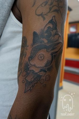 Toy rabbit and scrollwork dagger in black and grey on dark skin