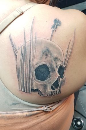 Unfinished skull with grass and an unfinished dandelion 