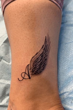 A with wings tattoo